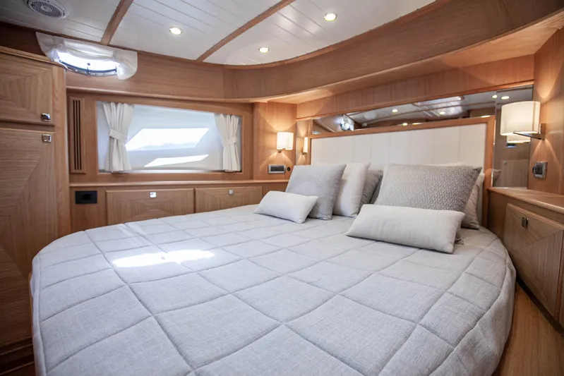Mareluna Yacht Photos Pics Luxurious bedroom interior of 2023 Vicem 55 yacht with elegant wood finish and plush bedding.