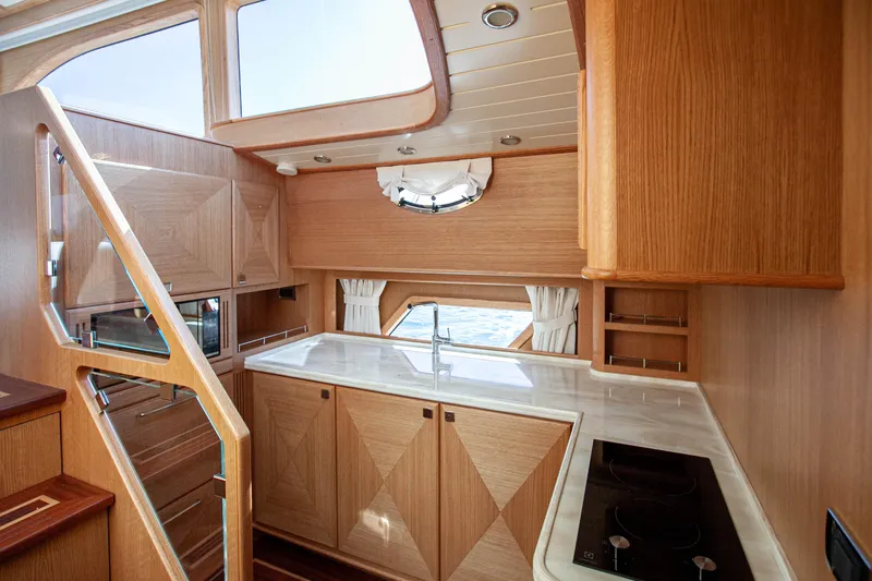 Mareluna Yacht Photos Pics Luxurious 2023 Vicem 55 yacht interior with modern kitchen design and wooden cabinetry.