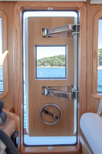 Mareluna Yacht Photos Pics Wooden door with window on 2023 Vicem 55 yacht, overlooking ocean and coastline.