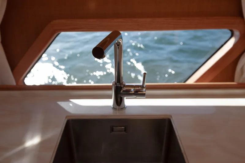 Mareluna Yacht Photos Pics Modern kitchen sink on Vicem 55 yacht, 2023, with ocean view through window.
