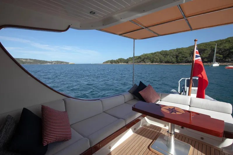 Mareluna Yacht Photos Pics Luxurious 2023 Vicem 55 yacht with elegant seating, scenic ocean view, and flag.