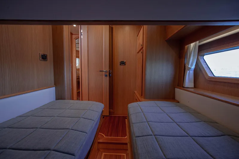 Mareluna Yacht Photos Pics Interior of 2023 Vicem 55 yacht cabin with twin beds and wooden finish.