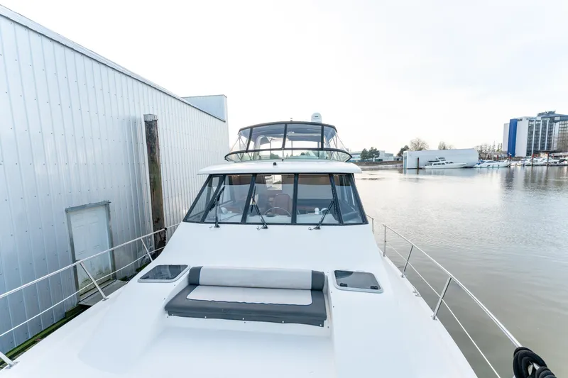 Seaclusion Yacht Photos Pics 1998 Bayliner 4788 Pilot House Motoryacht docked near a waterfront building.