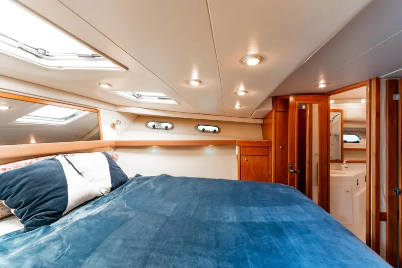 Seaclusion Yacht Photos Pics Luxurious bedroom interior of 1998 Bayliner 4788 Pilot House Motoryacht with skylights and wood accents.