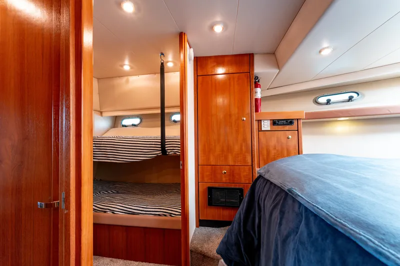 Seaclusion Yacht Photos Pics 1998 Bayliner 4788 Pilot House Motoryacht interior with cozy bunk beds and wooden cabinetry.