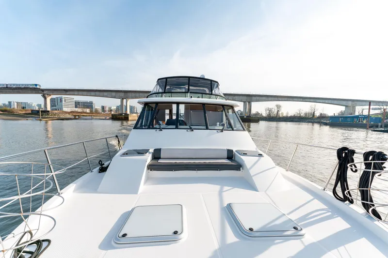 Seaclusion Yacht Photos Pics 1998 Bayliner 4788 Pilot House Motoryacht on calm water near a bridge.