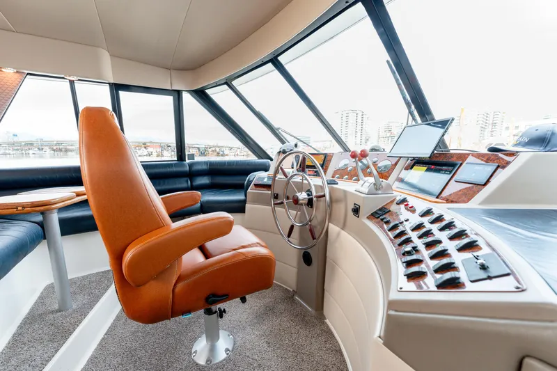 Seaclusion Yacht Photos Pics 1998 Bayliner 4788 Pilot House Motoryacht helm with leather chair and modern navigation controls.