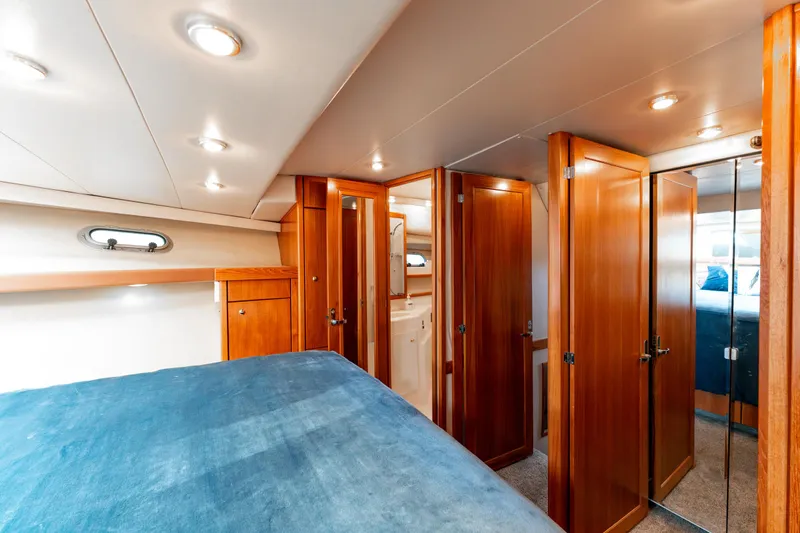 Seaclusion Yacht Photos Pics Luxurious interior of 1998 Bayliner 4788 Pilot House Motoryacht with wood finishes and cozy bedding.