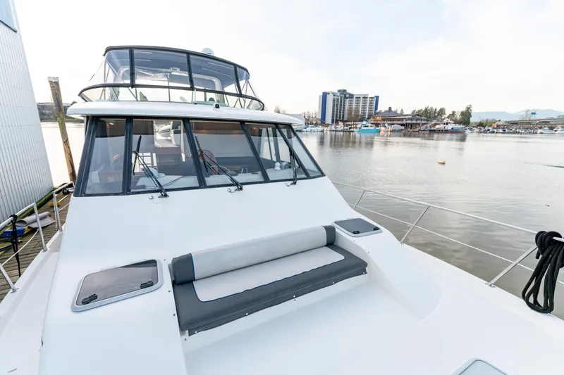 Seaclusion Yacht Photos Pics 1998 Bayliner 4788 Pilot House Motoryacht docked by waterfront buildings.