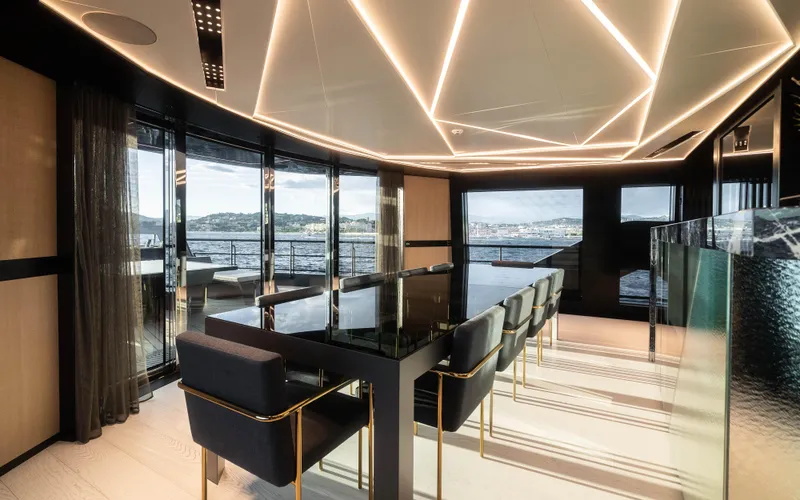 K+ Yacht Photos Pics Luxurious interior of 2023 Maori M 125 yacht with modern dining area and panoramic windows.