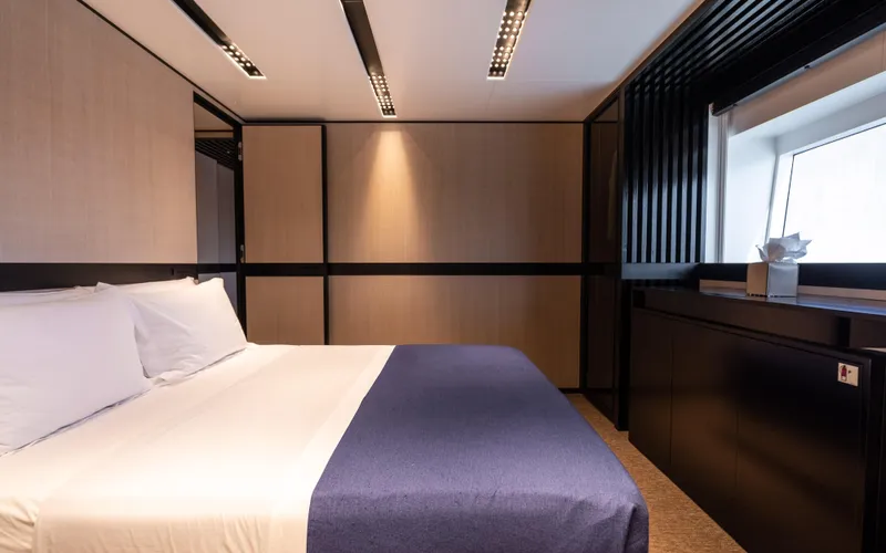 K+ Yacht Photos Pics Modern bedroom interior in Maori M 125 yacht, 2023 model, featuring sleek design and cozy ambiance.