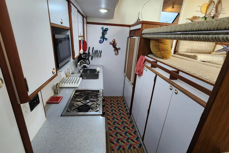 Tahawus Yacht Photos Pics Compact kitchen in 2005 Endeavour 44 TrawlerCat with stove, sink, and cozy decor.