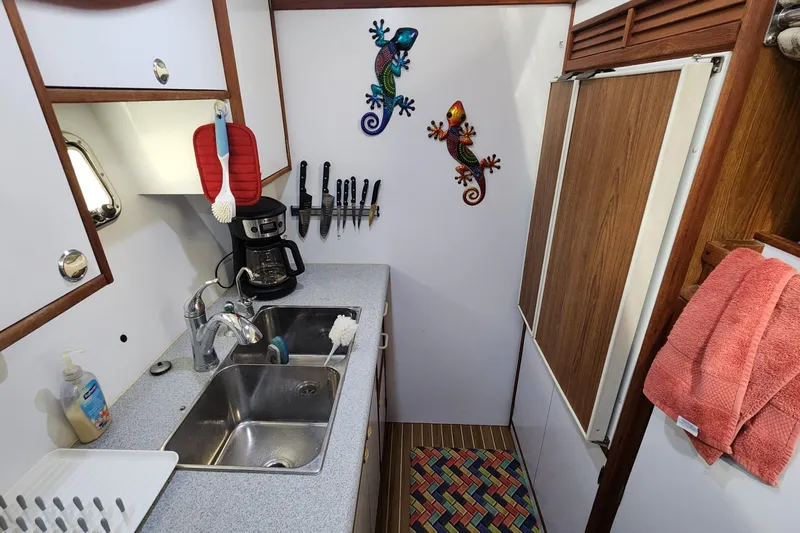 Tahawus Yacht Photos Pics Compact kitchen in 2005 Endeavour 44 TrawlerCat with sink, coffee maker, and colorful decor.