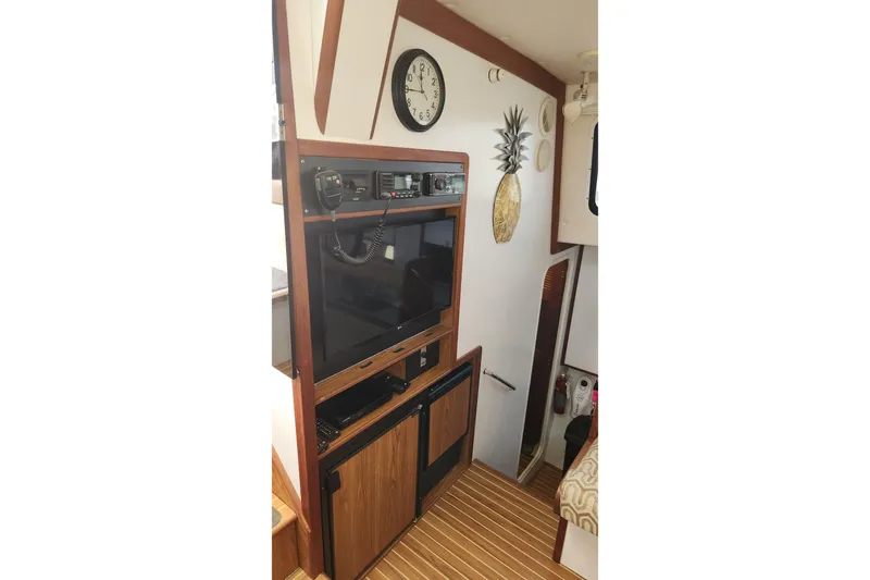 Tahawus Yacht Photos Pics 2005 Endeavour 44 TrawlerCat interior with electronics, clock, and pineapple wall decor.