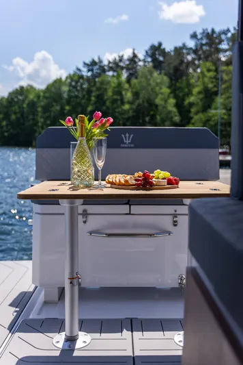  Yacht Photos Pics Luxury Nautic 880 boat with elegant dining setup, featuring flowers and fruit, on a sunny day.