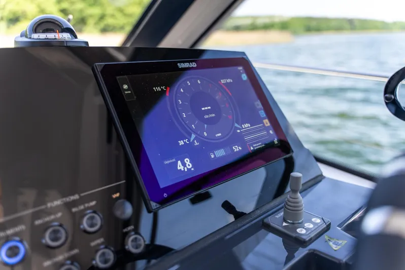  Yacht Photos Pics Control panel of 2025 Nautic 880 boat with digital display and joystick on a sunny day.