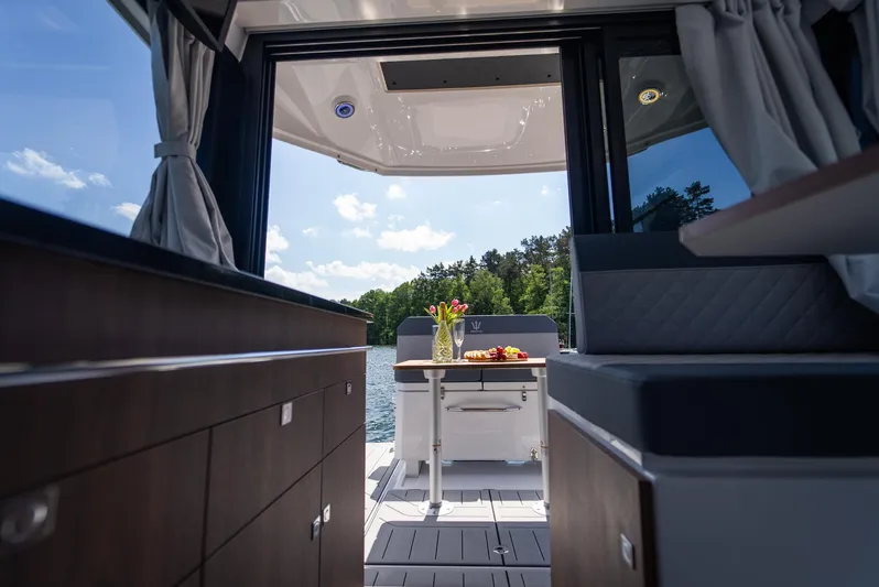  Yacht Photos Pics Luxurious interior of 2025 Nautic 880 yacht with lake view and elegant dining setup.