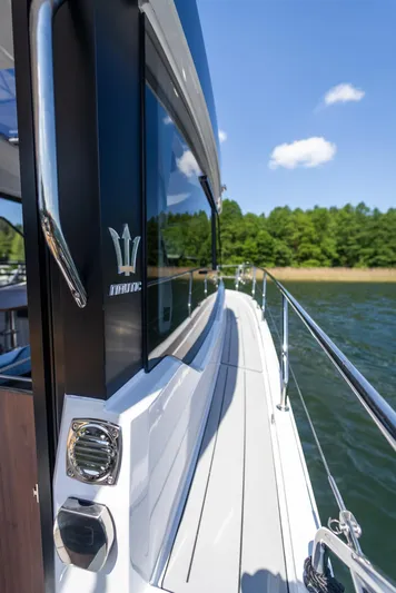  Yacht Photos Pics 2025 Nautic 880 yacht on water, sleek design, sunny day, lush green shoreline.