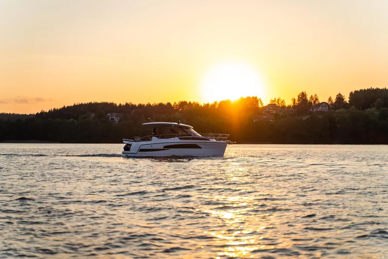  Yacht Photos Pics 2025 Nautic 880 boat cruising at sunset on a serene lake.