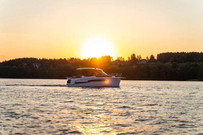  Yacht Photos Pics Nautic 880 boat cruising at sunset on a serene lake, 2025 model.