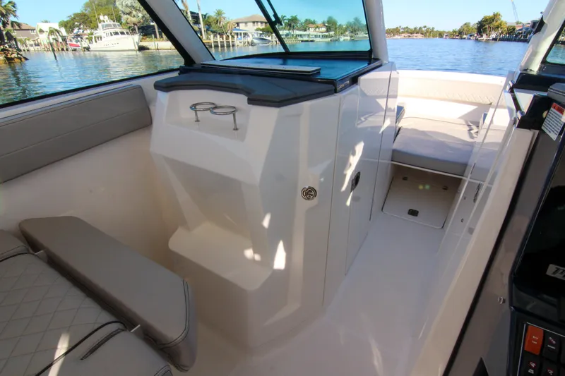 Endeavor Yacht Photos Pics 2023 Pursuit DC 295 Dual Console interior with seating and cup holders, dockside view.
