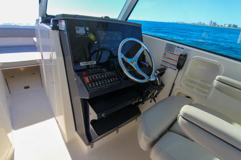 Endeavor Yacht Photos Pics 2023 Pursuit DC 295 Dual Console boat interior with steering wheel and control panel.