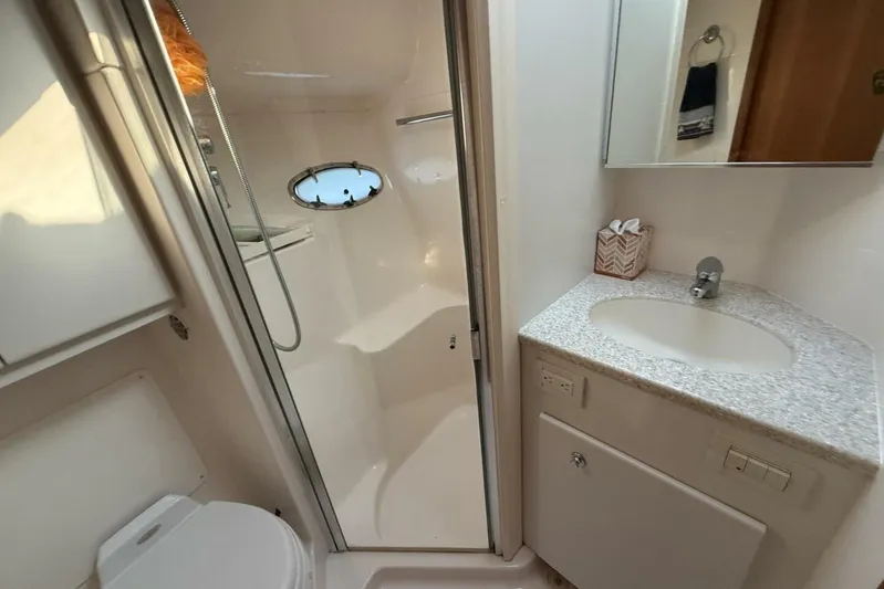 Grande Gator Yacht Photos Pics 2004 Tiara Yachts 4200 Open bathroom with shower, sink, and porthole window.