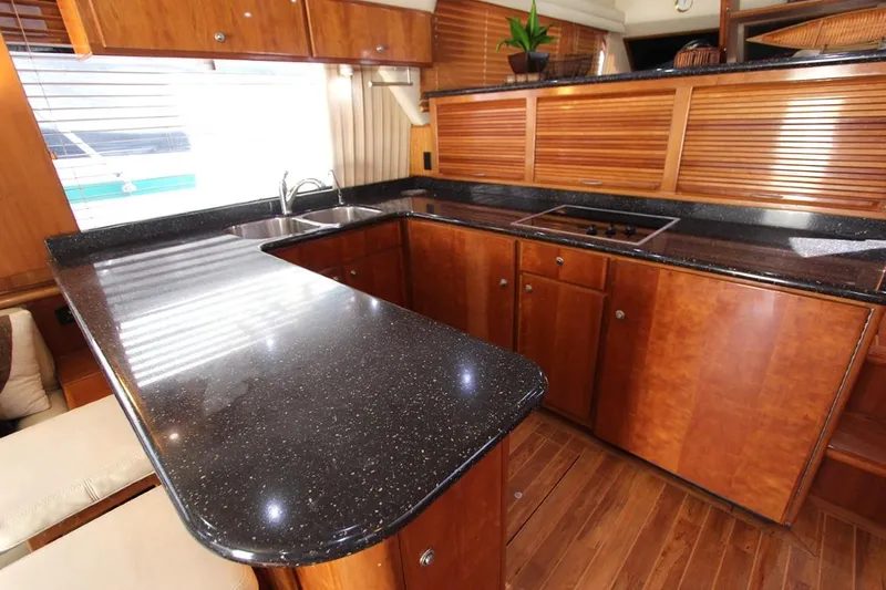 No Name Yacht Photos Pics Luxurious kitchen in 2006 Navigator 5400 yacht with sleek countertops and wooden cabinetry.