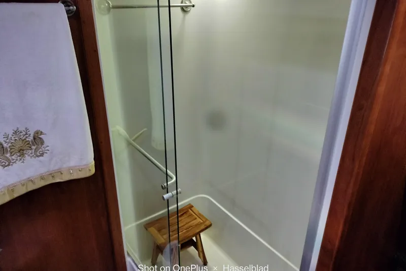 No Name Yacht Photos Pics Shower area in 2006 Navigator 5400 yacht with wooden stool and decorative towel.