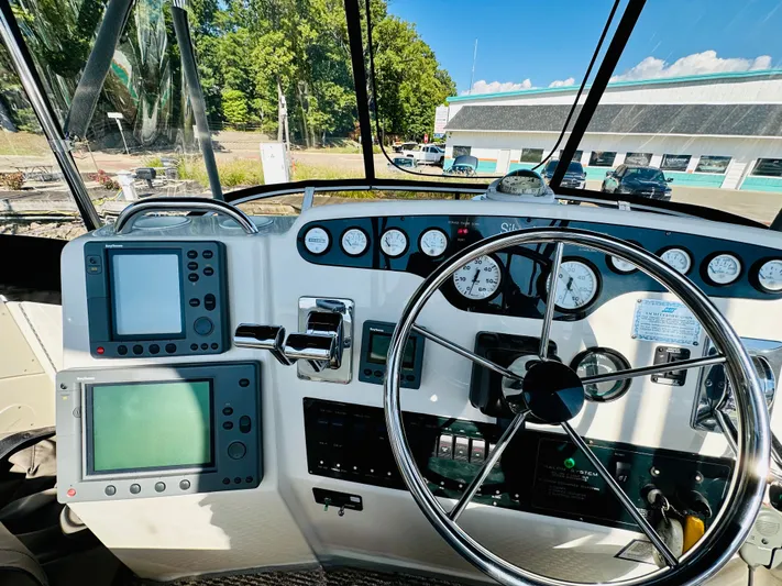 Precious Time Yacht Photos Pics 1998 Silverton 392 Motor Yacht helm with gauges, steering wheel, and navigation equipment.