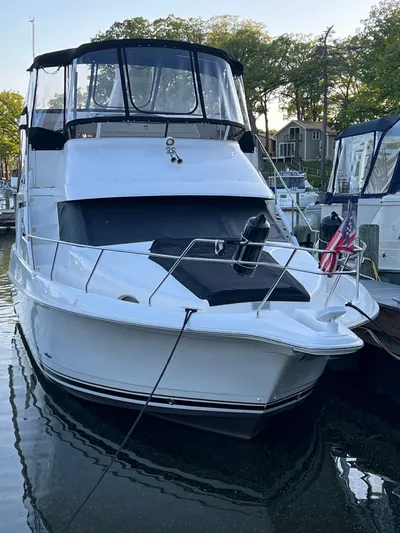 Precious Time Yacht Photos Pics 1998 Silverton 392 Motor Yacht docked at marina, featuring sleek design and American flag.