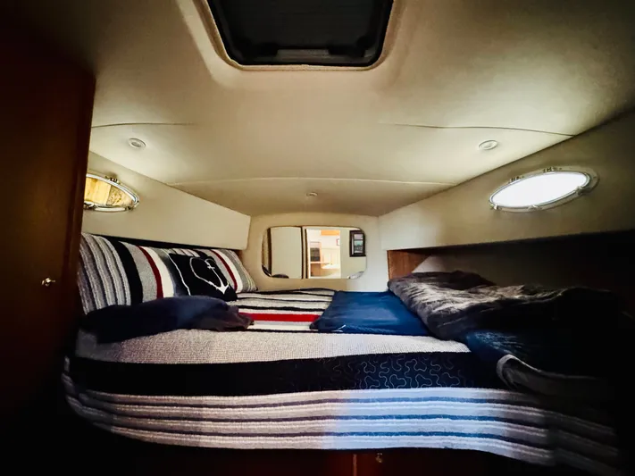 Precious Time Yacht Photos Pics Cozy cabin interior of 1998 Silverton 392 Motor Yacht with striped bedding and porthole windows.