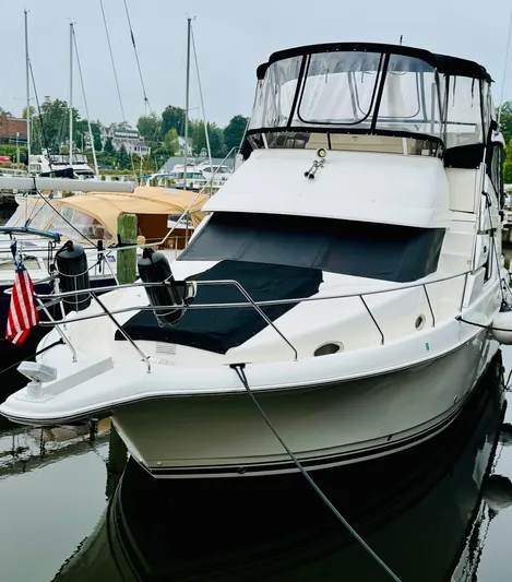 Precious Time Yacht Photos Pics 1998 Silverton 392 Motor Yacht docked at marina, featuring sleek design and American flag.