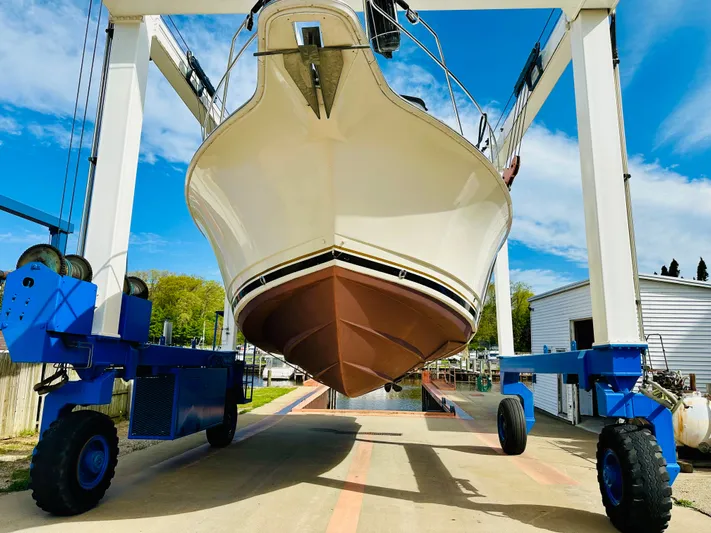 Precious Time Yacht Photos Pics 1998 Silverton 392 Motor Yacht in dry dock, showcasing hull and lift equipment.