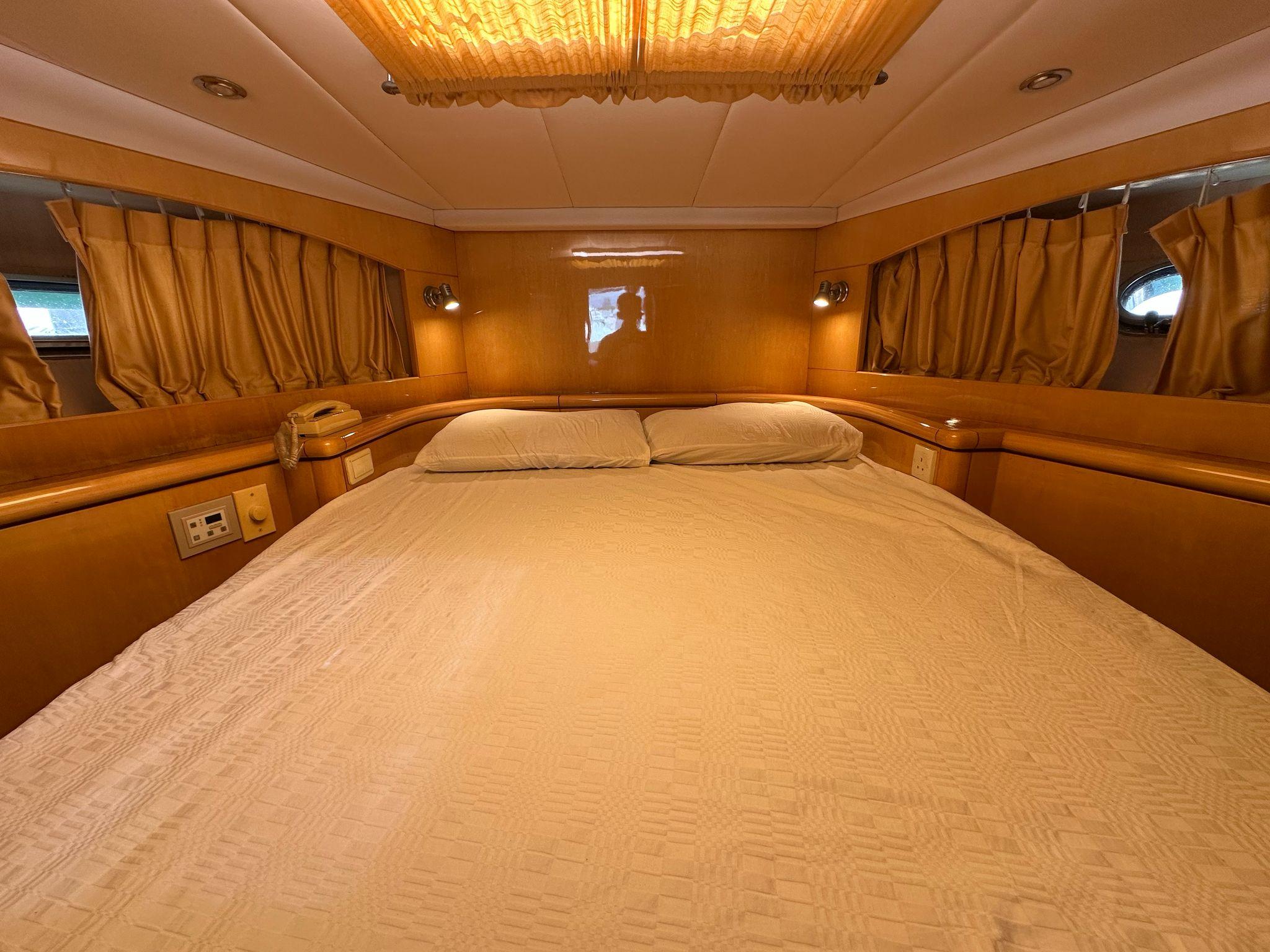 Luxurious cabin interior of a 2005 Ruby 45 yacht with cozy bedding and warm lighting.