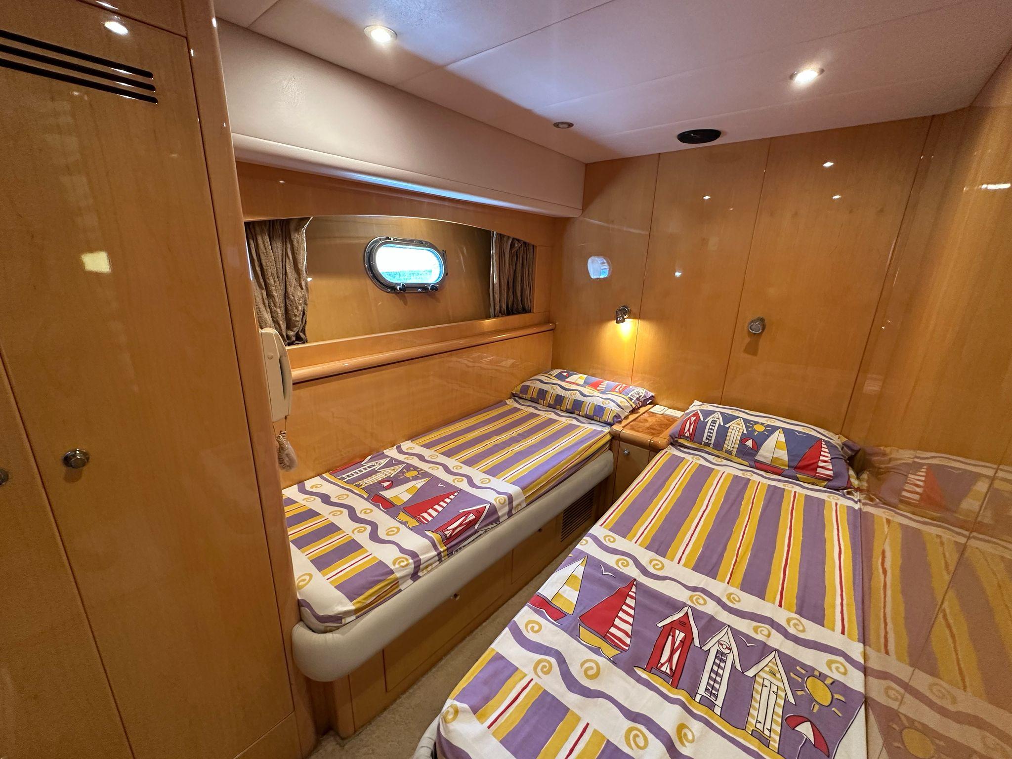 Twin beds in a 2005 Ruby 45 yacht cabin with nautical-themed bedding.