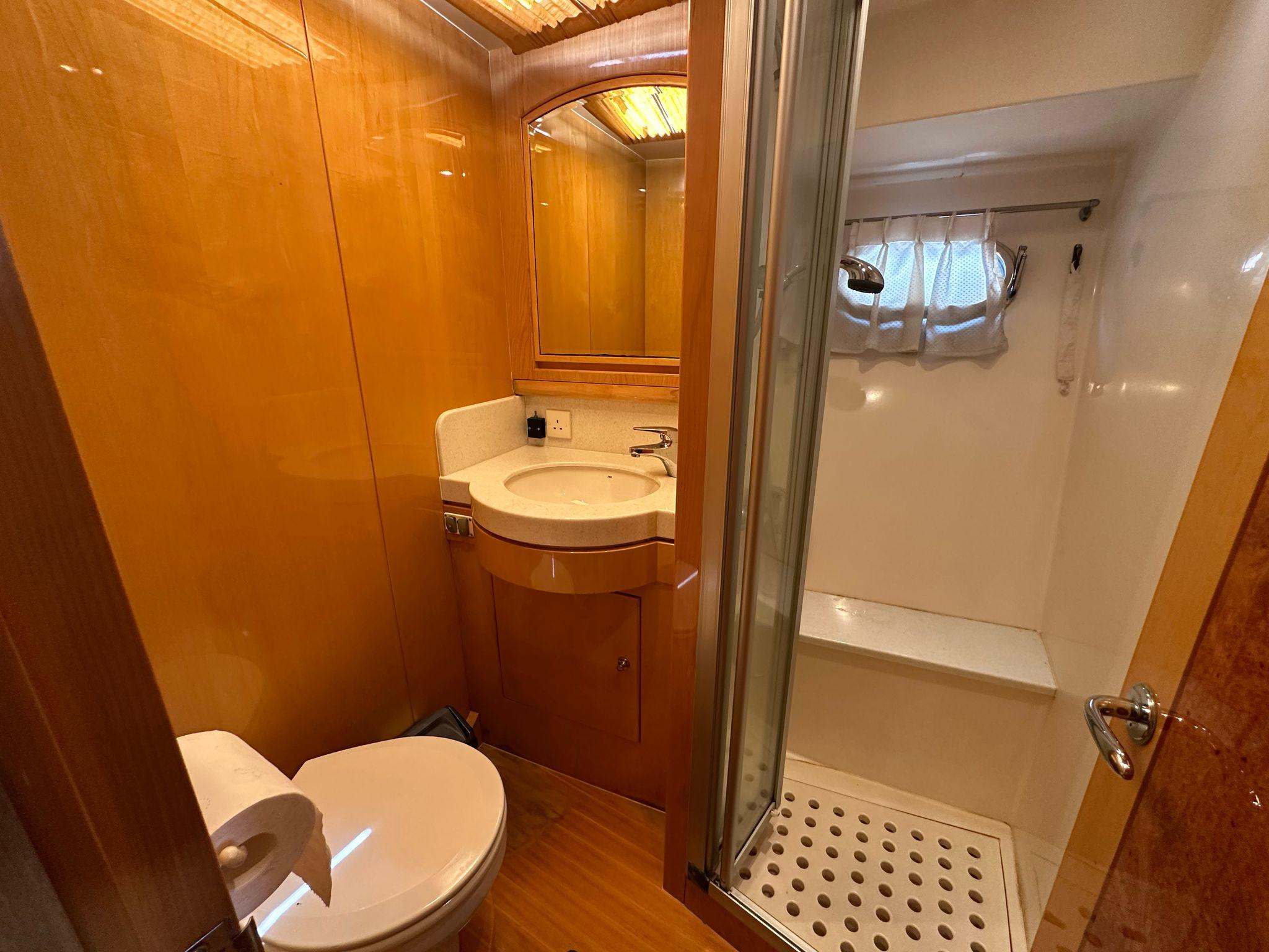 Compact yacht bathroom with wooden paneling, shower, toilet, and sink. Ruby 45, 2005 model.