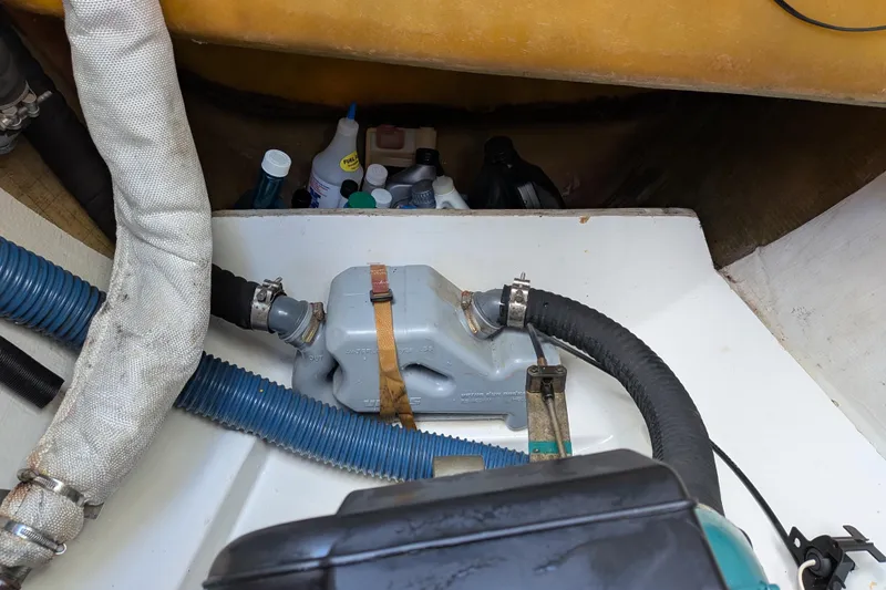 Imany Yacht Photos Pics Engine compartment of 2012 Fountaine Pajot Lipari with hoses and maintenance supplies.