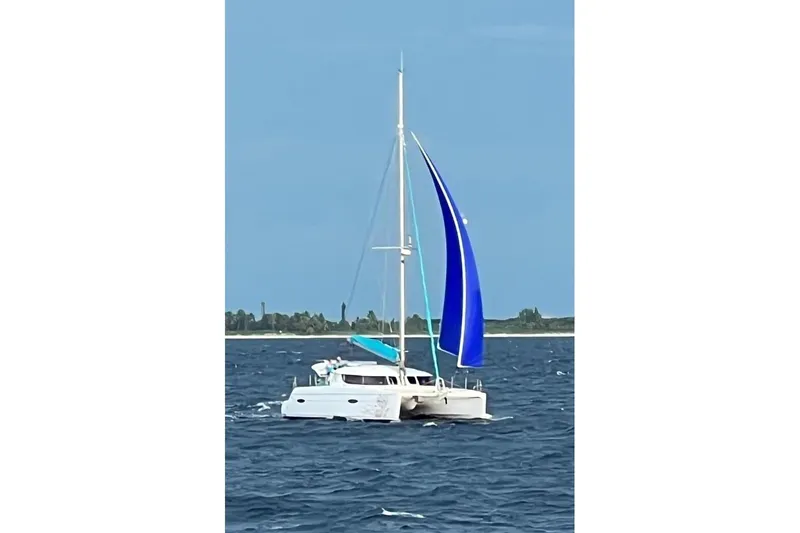 Imany Yacht Photos Pics 2012 Fountaine Pajot Lipari catamaran sailing on open water with blue sail.