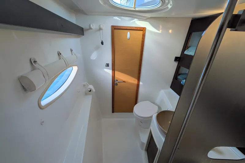 Imany Yacht Photos Pics Bathroom interior of 2012 Fountaine Pajot Lipari catamaran, featuring modern fixtures and porthole window.
