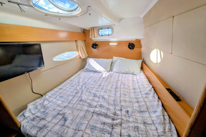Imany Yacht Photos Pics Cozy cabin interior of 2012 Fountaine Pajot Lipari catamaran with bed and porthole views.