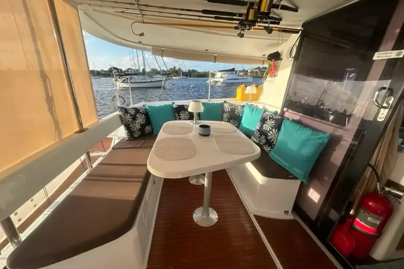 Imany Yacht Photos Pics 2012 Fountaine Pajot Lipari catamaran interior with cozy seating and scenic marina view.