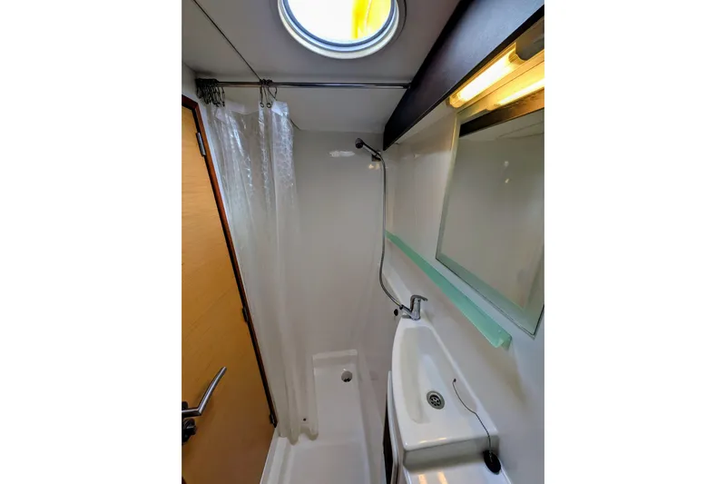 Imany Yacht Photos Pics Compact bathroom in 2012 Fountaine Pajot Lipari catamaran with shower, sink, and porthole.