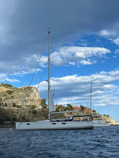  Yacht Photos Pics 2013 Beneteau Sense 55 sailboat on scenic coastal waters under a partly cloudy sky.
