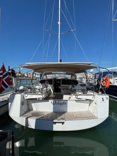  Yacht Photos Pics 2013 Beneteau Sense 55 sailboat docked, rear view, with clear blue sky.