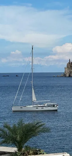  Yacht Photos Pics 2013 Beneteau Sense 55 sailboat on calm sea near rocky coastline.