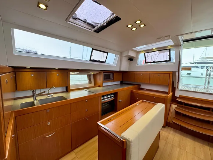  Yacht Photos Pics Luxurious interior of 2013 Beneteau Sense 55 yacht with modern kitchen and wooden cabinetry.