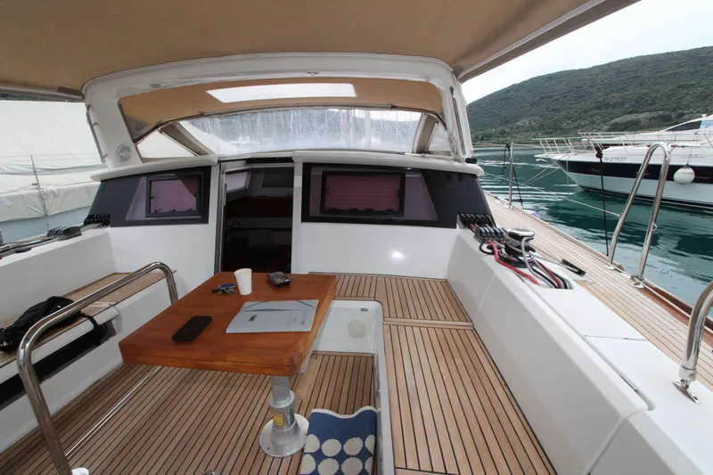  Yacht Photos Pics 2013 Beneteau Sense 55 yacht cockpit with wooden table, docked in a marina.