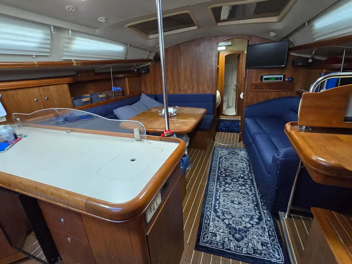 Scuba Duo Yacht Photos Pics Interior of a 2004 Hunter 41 AC sailboat with wood finish and blue seating.