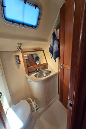 Scuba Duo Yacht Photos Pics 2004 Hunter 41 AC yacht bathroom with sink, mirror, and wooden cabinetry.